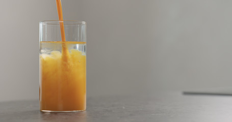 sea buckthorn juice pour into beaker glass with water on concrete surface