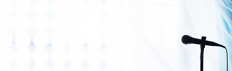 Stand with a microphone. Man holds hands a microphone on a tripod. Performance of the artist with a microphone. Scene with a microphone.