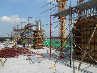 MALACCA, MALAYSIA -JUNE 18, 2016: Construction workers fabricating column timber form work and reinforcement bar at the construction site in Malacca, Malaysia. 
