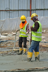 SELANGOR, MALAYSIA -JUNE 18, 2016, : Construction workers using a concrete vibrator at the construction site to compact the concrete slurry that pours in the form work. 