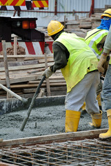 SELANGOR, MALAYSIA -JUNE 18, 2016, : Construction workers using a concrete vibrator at the construction site to compact the concrete slurry that pours in the form work. 