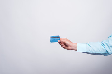 Close up photo of man hand showing blue credit card.