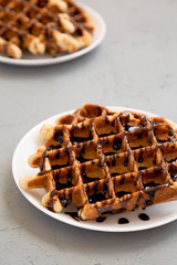 Homemade Belgian Waffles on a white plate on a gray background, side view. Close-up.