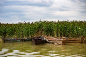 Old boats on lake summer day dramatic sky 