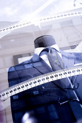 Mannequin in a mens suit surrounded by a tailors tape measure