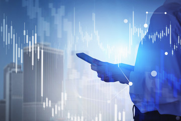 Woman with smartphone in city, financial graphs