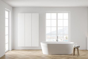 Fototapeta na wymiar White bathroom with tub and cabinet