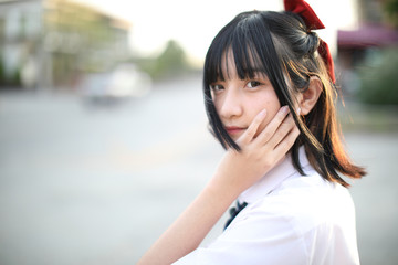 Asian school girl walking and looking at urban city