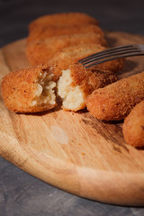 Homemade traditional spanish croquettes on a wood board and black background. Tapas food. Dark food.