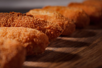 Homemade traditional spanish croquettes on a wood board and black background. Tapas food. Dark food.