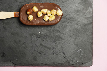 Chocolate ice cream with organic hazelnuts on dark slate background. flat lay. gastronomic food
