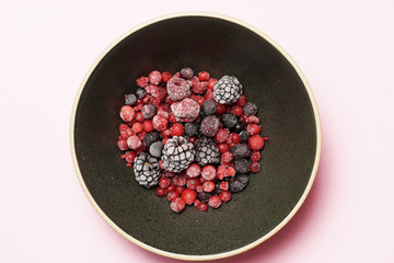 Red berries and black berries on a black plate and slate background. flat lay. gastronomic food