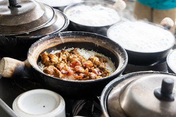 Steamy hot clay pot chicken rice being cooked in restaurant. Popular food in Malaysia