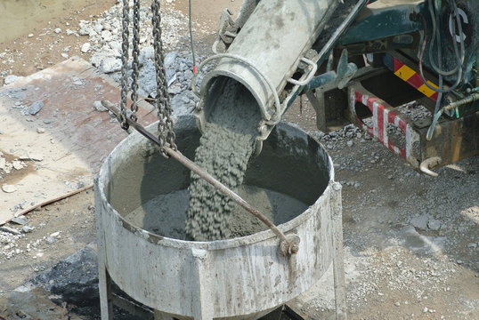 SELANGOR, MALAYSIA -JUNE 06, 2016: Concrete mixer lorry pouring wet concrete into concrete bucket. 