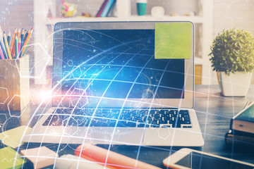Double exposure of desktop with computer and world map hologram. International data network concept.
