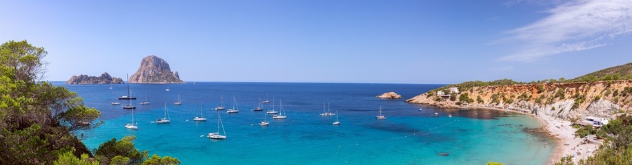 Beautiful  panorama of the beach Cala Hort and the mountain Es Vedra with sea sailing yachts. Ibiza, Balearic Islands, Spain