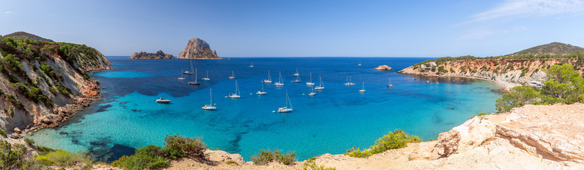 Hyper panorama of Cala Hort with sea sailing yachts and the mountain Es Vedra. Ibiza, Balearic...