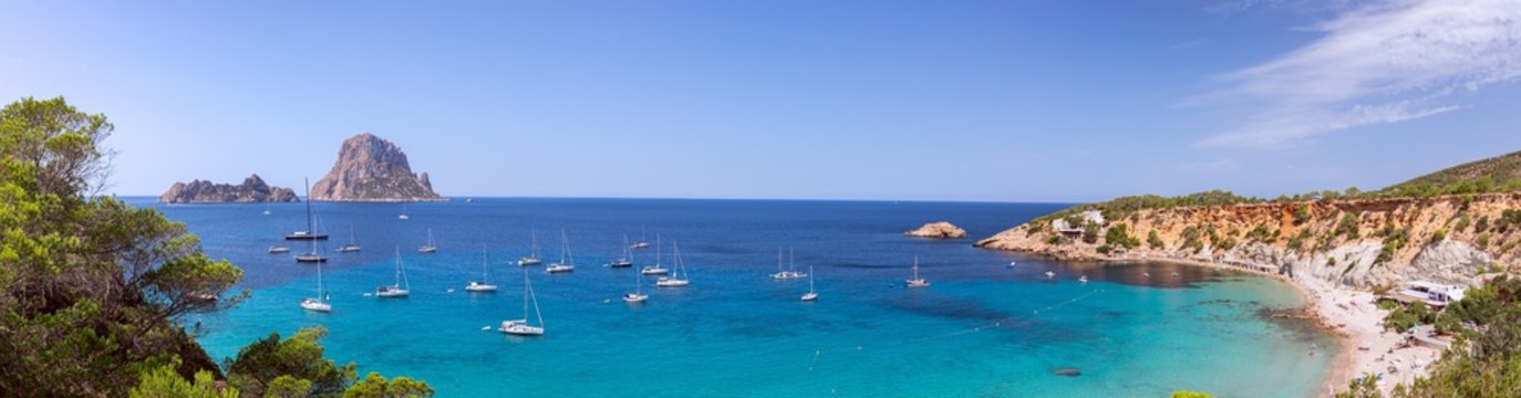 Beautiful  panorama of the beach Cala Hort and the mountain Es Vedra with sea sailing yachts. Ibiza, Balearic Islands, Spain