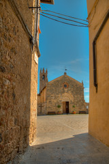 Fototapeta na wymiar petite chapelle médiévale sur une ruelle ocre à Monteriggioni en Toscane Italie
