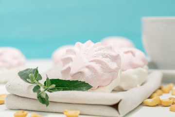 healthy sweets. delicate marshmallow with a mint leaf on a blue light background