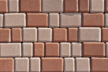 Obraz premium Cobblestone texture. The sidewalk tile is evenly folded. Brown cobblestones close up.