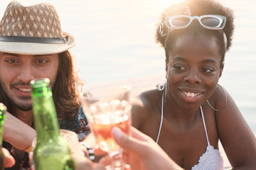 Young couple sitting at the table and talking to their friends outdoors