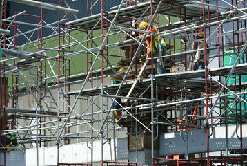 
MALACCA, MALAYSIA -MAY 13, 2016: Construction workers working at the construction site at Malacca, Malaysia during daytime. They are wearing proper safety gear so ensure they are safe working.  