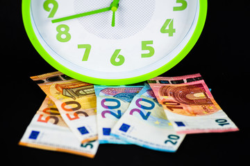 euro banknotes under a clock