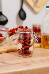 Sun-dried tomatoes. The process of cooking sun-dried tomatoes. The woman is preparing tomatoes in the kitchen. A woman cuts tomatoes, greases them with oil and spices them. 