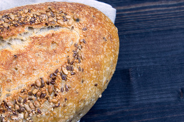 Rye bread with sunflower seeds and flax seeds on a dark wooden background. Fresh bread. Close-up....