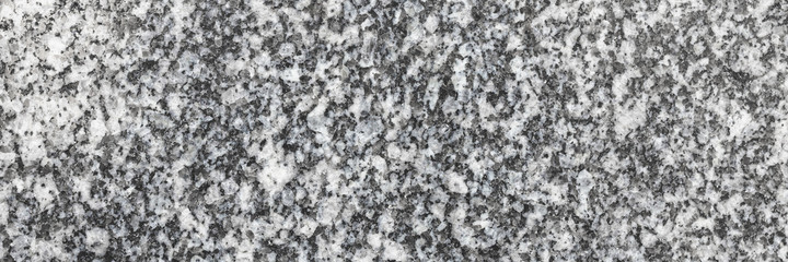 Granite texture. Natural granite with a grainy pattern. Stone background. Solid rough surface of rock. Durable construction and decoration material. Close-up.