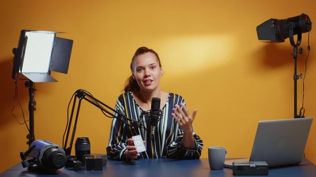Video blogger doing a mini LED light review in her professional studio set.