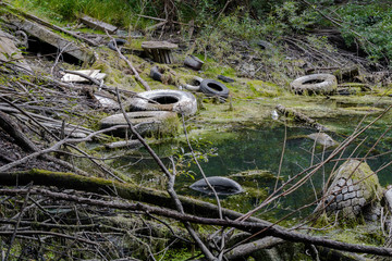 Contaminated lake. Polluted lake with car tires.