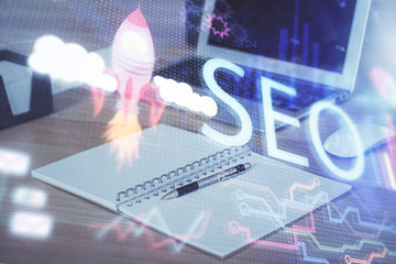 Multi exposure of table with computer and seo drawing hologram. Search optimization concept.