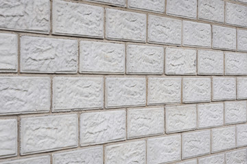 The wall of the house is made of gray concrete blocks. Background or wallpaper. The masonry seams form a perspective. Backdrop on the topic of housing construction and renovation