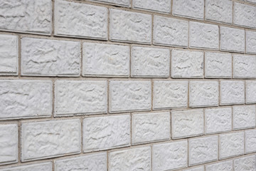 Obraz premium The wall of the house is made of gray concrete blocks. Background or wallpaper. The masonry seams form a perspective. Backdrop on the topic of housing construction and renovation