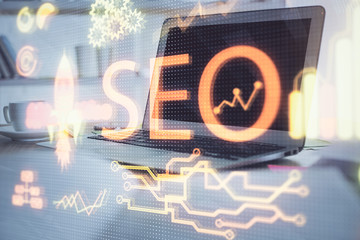 Multi exposure of table with computer and seo drawing hologram. Search optimization concept.