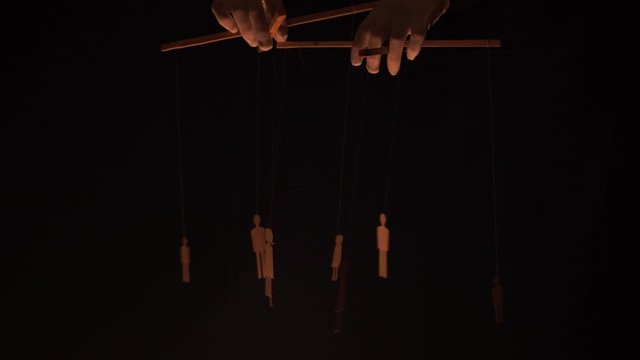 Puppet master and marionettes. Manipulations with the mind and actions of people concept