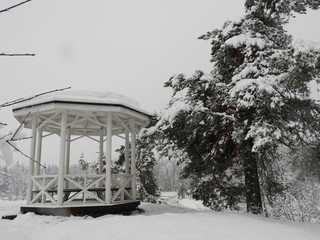 White Chinese style gazebo perched on a rock in winter in the snow