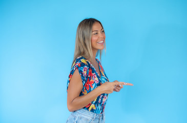 Pretty blond woman pointing on blue background