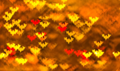 Abstract background for Halloween, bokeh in the form of bats in red, yellow and orange on a dark background. Space for text