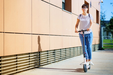 Woman riding around town on an electric scooter