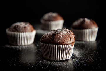 muffin dessert on black background with sugar powder