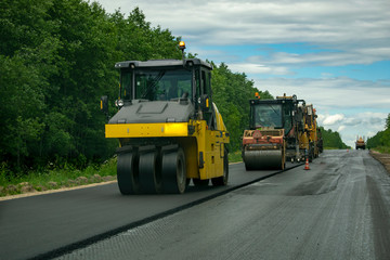 Laying asphalt on the road using heavy equipment.  Asphalt road construction.