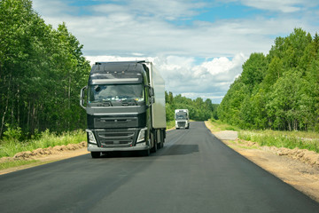 Fototapeta na wymiar Truck on the road with a wagon full of cargo.