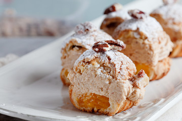 Classic French dessert eclair, choux pastry filled with soft hazelnut cream mango-passionfruit coulis