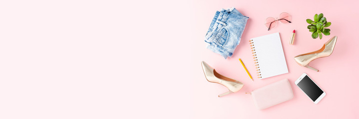 Woman’s fashion with clothes, golden high heels and empty notebook. Banner. Top view