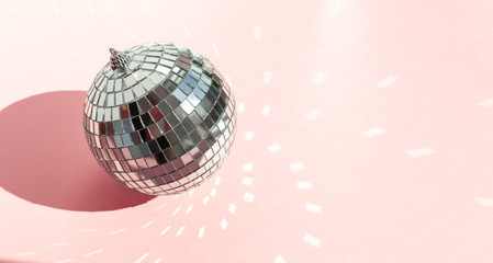 Shining disco ball on pink background. Disco ball with bright rays
