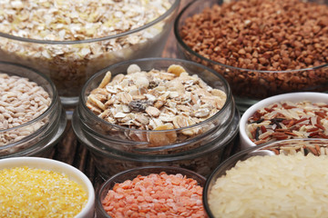 A set of bowls filled with different seeds: buckwheat, rise, corn and oatmeal	