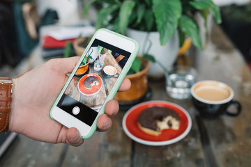 Man taking still life photos at cafe. Photo content for social media.